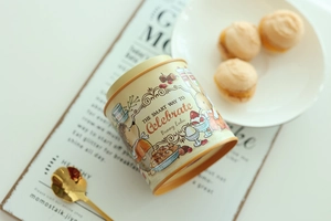 Detailed view of mini tinplate storage jar with bunny illustration and tea scene props