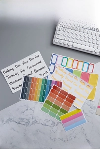 Macro detail of assorted multi-color planner labels with English categories and icons