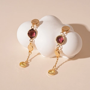 Detail of vintage geometric earrings with purple glass beads on a cloud display stand