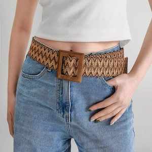 Close-up of wide woven straw belt featuring a square wooden buckle and brown wavy texture