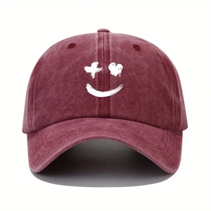 Detail of burgundy washed cotton baseball cap featuring creative white smile graphic