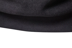 Macro shot of high-quality black knit fabric with detailed rib-knit hem and soft texture