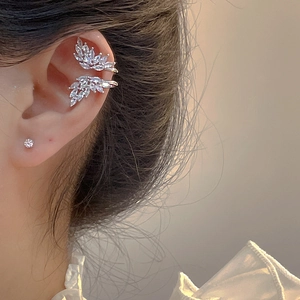 Détail d'un ear cuff feuille en argent avec zircons marquise étincelants sur l'oreille