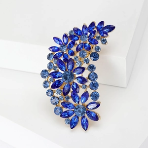 Detailed view of the blue crystal flower brooch with marquise-cut stones on metal