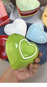 Detailed view of handmade heart-shaped ceramic bowls in various pastel candy colors