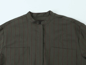Detailed close-up of a dark olive green striped shirt with stand collar and double pockets