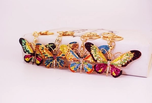 Detail showing four colorful crystal butterfly keychains with gold metal plating