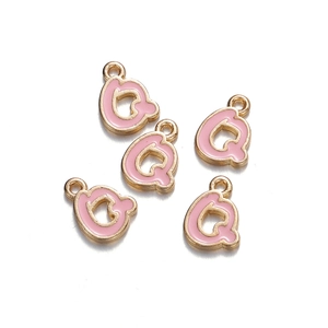 Detail shot of five pink enamel letter Q charms with gold loops for DIY jewelry