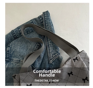 Close-up of grey corduroy tote bag showing black bow prints and quilted diamond stitching