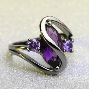 Detail view of gunmetal ring with marquise purple zircon in streamlined crossover setting