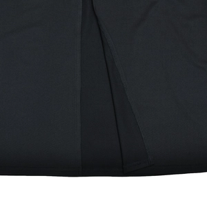 Dettaglio del tessuto plissettato nero che mostra lo spacco elegante e la trama