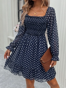 Detailed close-up of dark blue polka dot dress with square neck and smocked bodice