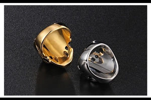 Macro shot of gold and silver skull rings with polished metallic finish on black background