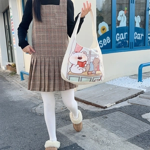 Detail of canvas tote bag showing the cartoon bear print and long shoulder strap