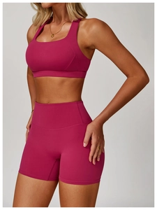 Close-up of berry red high-waisted yoga shorts and sports bra with supportive elastic fabric