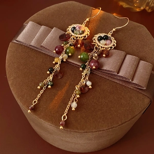 Detailed close-up of vintage flower tassel earrings with colorful beads and gold chain