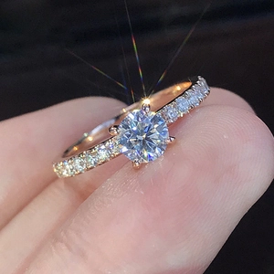 Elegant rose gold solitaire engagement ring with zircon stones held by hand