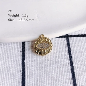 Detailed view of evil eye alloy pendant with white rhinestones measuring 14x13x2mm
