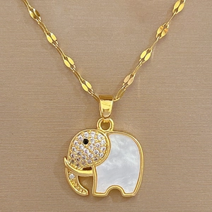 Macro view of gold elephant pendant featuring white shell inlay and sparkling crystals