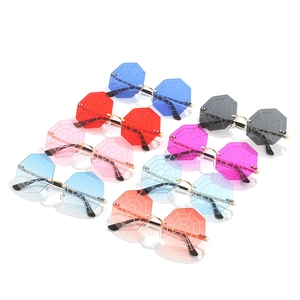 Octagonal rimless sunglasses featuring laser-etched spider web lenses and gold metal frames