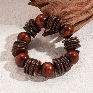 Macro shot of vintage wooden beaded bracelet with coconut shell discs on stone surface