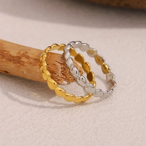 Detail of gold and silver heart-edged minimalist rings displayed on natural wood stands