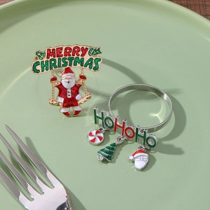 Detail of Santa Claus and Hohoho metal napkin rings with colorful enamel decorations