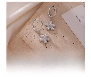 Detailed macro view of silver titanium steel flower earrings with teardrop zircon stones