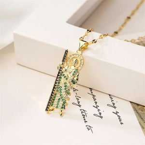 Detail of 18K gold plated saint pendant necklace with green and white cubic zirconia