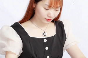 Detail of silver chain necklace with a concentric circular pendant on a female model