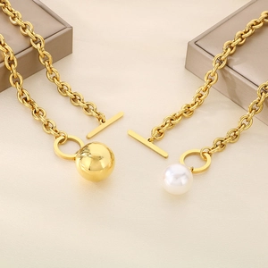 Detail of gold chain necklaces with OT toggle clasp, large gold ball and white pearl pendant