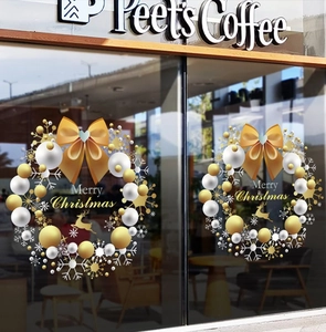 Detail of Christmas wreath window stickers with Merry Christmas text on coffee shop glass