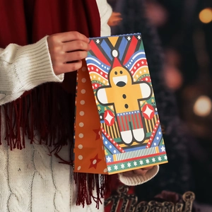 Christmas kraft paper gift bag featuring colorful gingerbread man pattern in festive setting