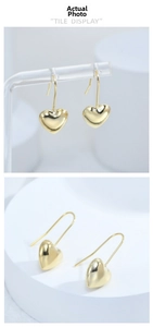 Detailed view of 3D heart drop earrings in polished gold plating with elegant long hooks
