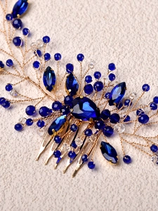 Detailed close-up of bridal hair comb with blue crystals and gold wire weaving