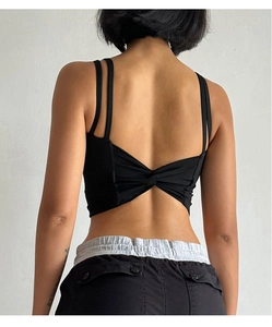 Close-up of black sports bra featuring a strappy criss-cross back with knot detail