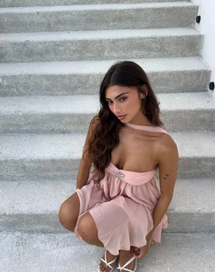 Detail of pink chiffon mini dress featuring halter neck and star-shaped metal buckle