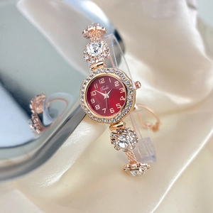 Detail of rose gold adjustable bracelet watch with a red dial and sparkling rhinestones