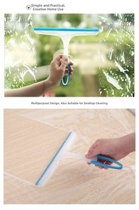 Close-up of a blue silicone squeegee cleaning a glass window and a wooden tabletop surface