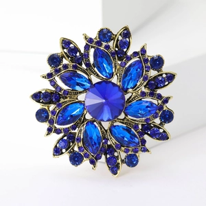 Detailed close-up of a vintage floral brooch with deep blue crystals and gold-tone finish