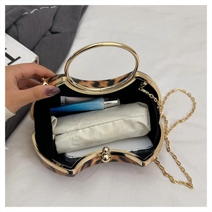 Detailed interior of leopard print evening clutch with gold handle and chain strap