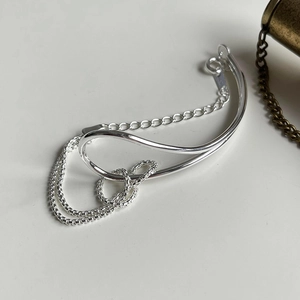 Macro detail of S925 sterling silver knotted bracelet showing polished metal and extension chain