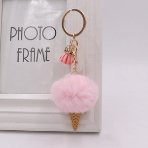 Detail of pink plush ice cream keychain with golden ring and small tassel accessory