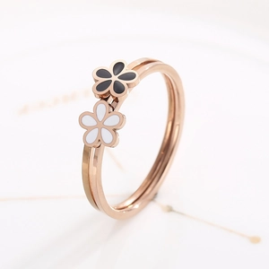 Vue macro d'une bague double en acier inoxydable rose doré avec fleurs noires et blanches