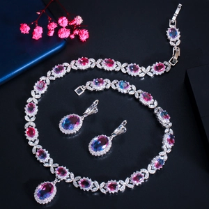 Macro view of bridal jewelry set featuring pink and blue gradient stones on black background