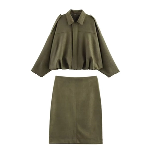 Flat lay of an olive green two-piece suede set featuring a cropped jacket and midi skirt