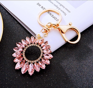 Detail of pink crystal sunflower keychain with gold metal ring and pearl accent