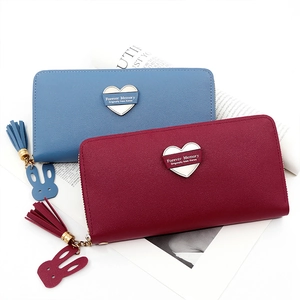 Detailed view of long zip wallet with heart patch, fringe tassel and rabbit pendant charms
