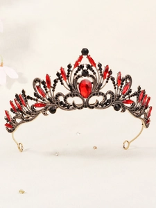 Close-up of vintage gold bridal crown featuring red teardrop gems and black rhinestones