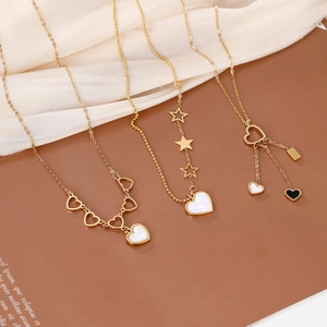 Three-piece set of gold heart and star pendant necklaces on elegant silk fabric